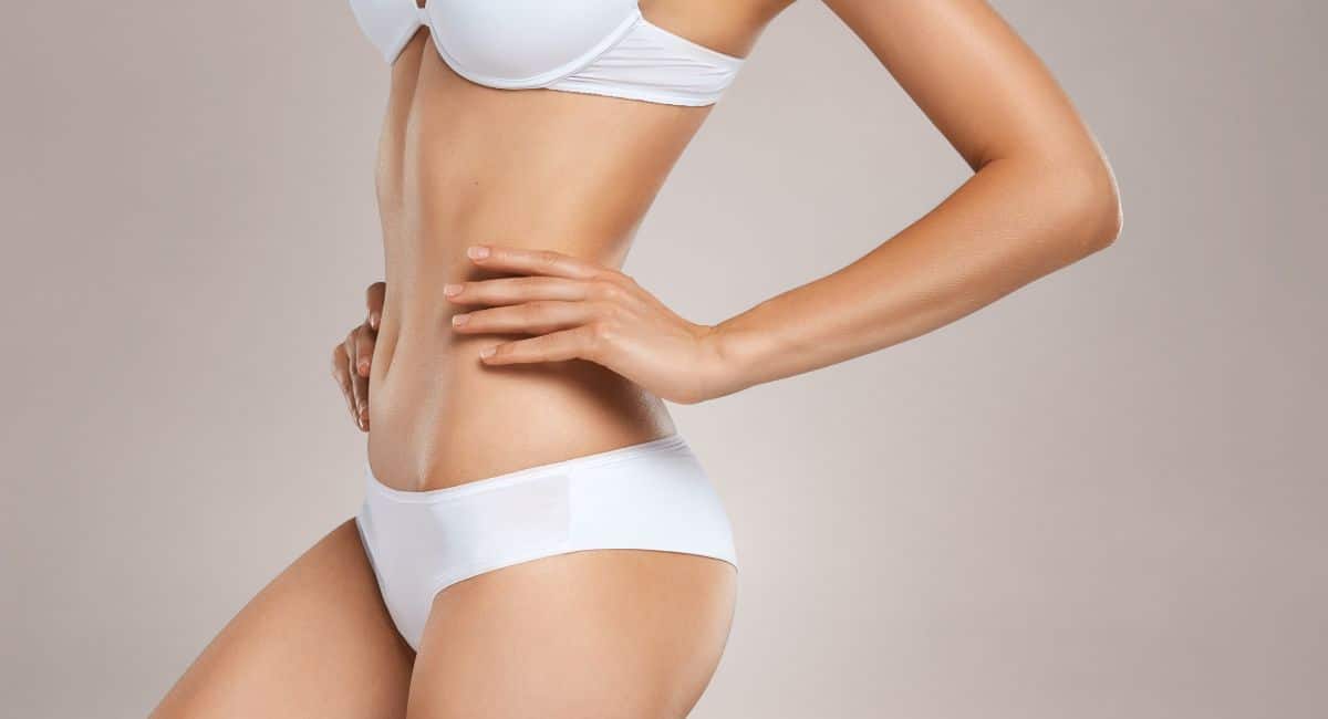 a woman showcasing her attractive body form while wearing a white bra and underwear